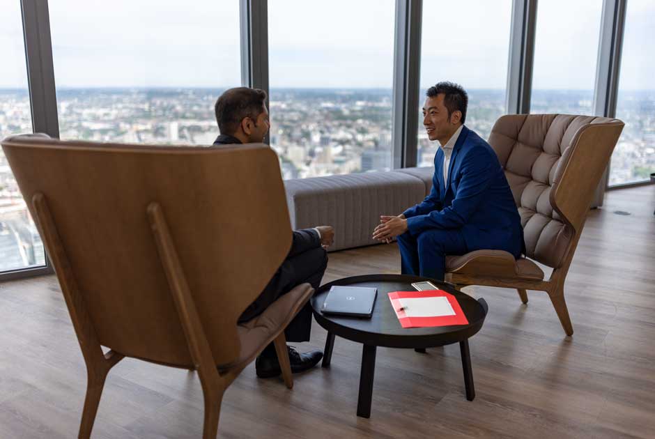 A pair of investment executives chat in 69ɫƬ's London, U.K. office.
